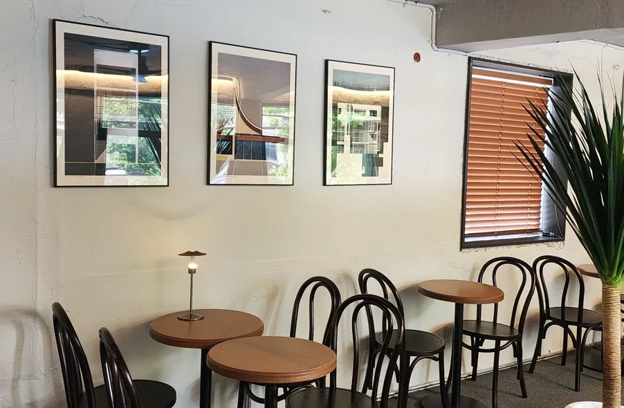 A white-walled seating area with round chairs and framed art at Central Site Coffee Roasters Yeonnam.