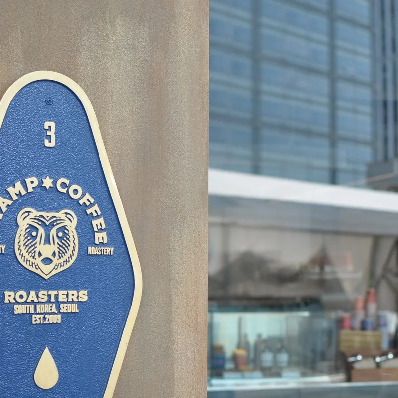 Blue Champ Coffee Third Workshop sign with three bear figures on the Daerim Arcade level.