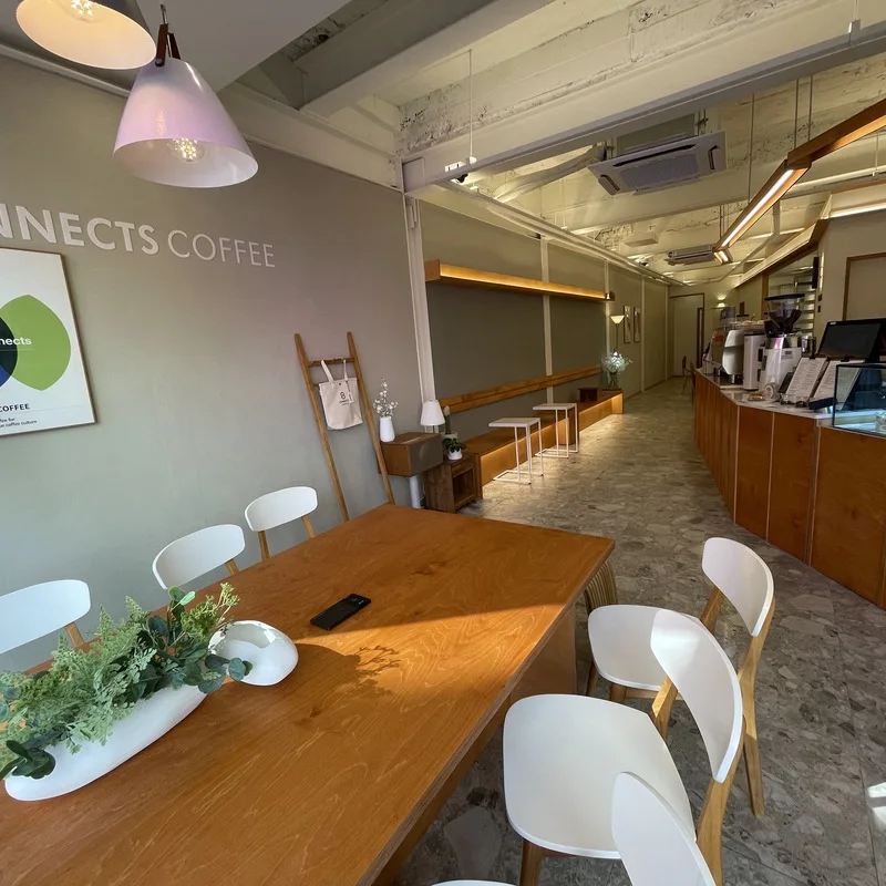 The narrow, warmly lit room and branded counter area at Connects Coffee Mangwon.