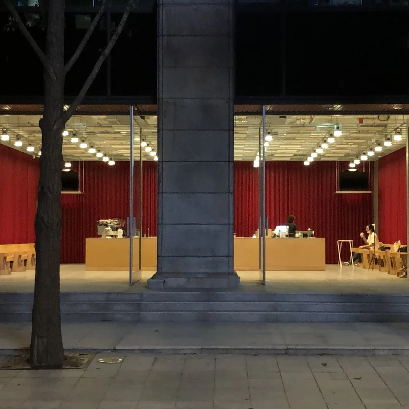 Glass frontage, large structural pillar and red interior of Felt Coffee Cheonggyecheon.