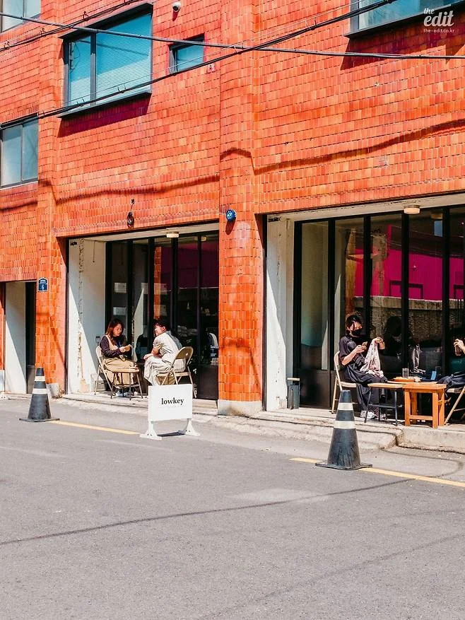 Orange brick façade and pavement seating at Lowkey Seongsu