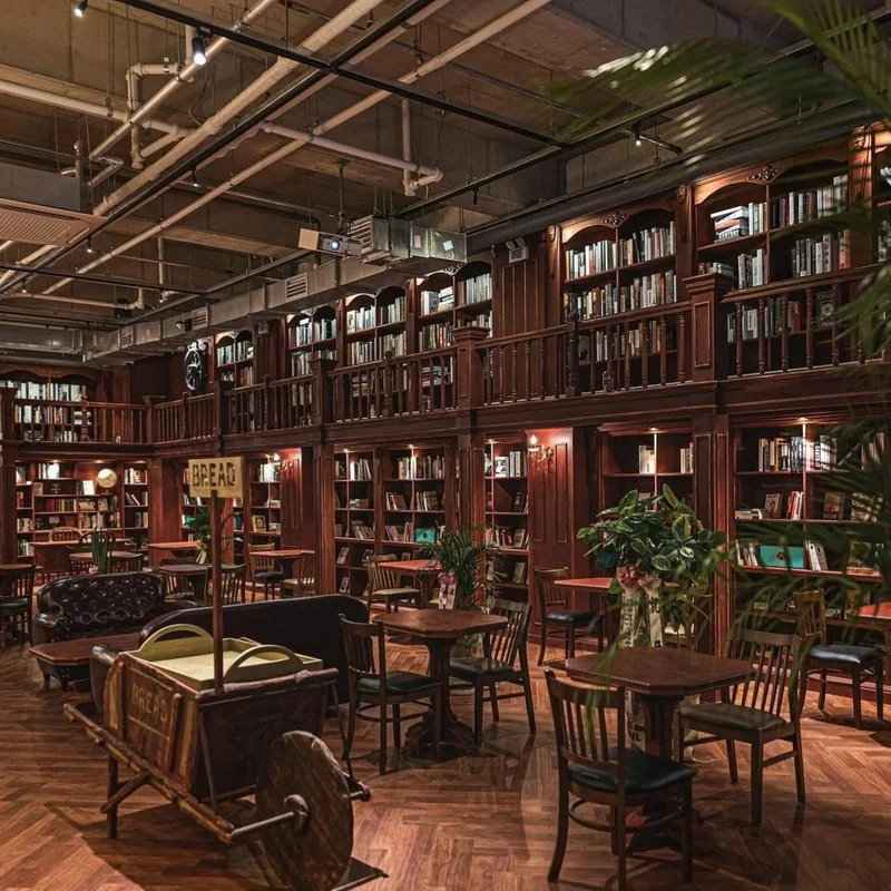 Book-lined walls and wooden café tables in Manhole Coffee’s Dangsan basement