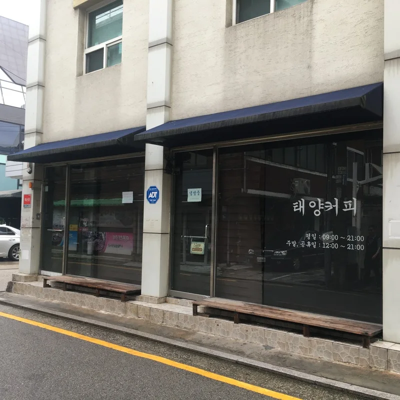 Dark glass storefront of Taeyang Coffee Bangbae with its Korean name on the window