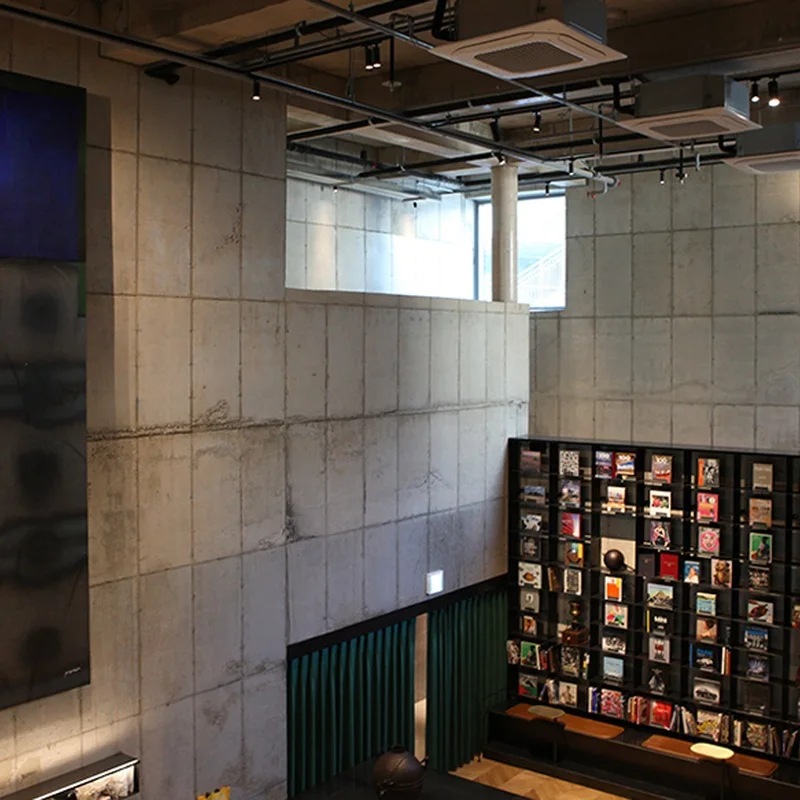 High concrete walls, clerestory window and book shelving at Terarosa Gildong