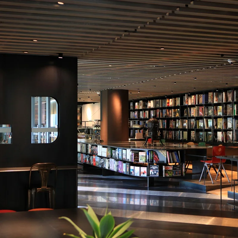 Dark wooden seating, tall bookshelves and slatted ceiling inside Terarosa at MMCA Seoul.